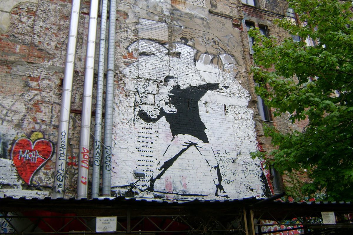 Berlin, one of Banksy's Flowerthrowers, next to the F-ck Banksy tag